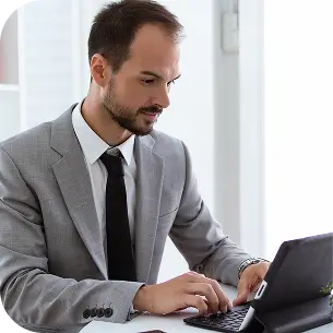Ejecutivo trabajando en laptop dentro de oficina moderna